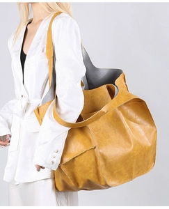 Model wearing a large ginger yellow tote bag with vintage faux leather texture