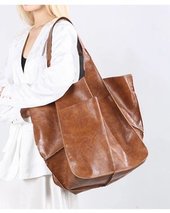 Detail of vintage caramel tote bag showing large front pocket and soft leather texture