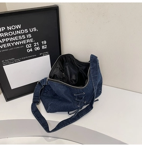 Détails du sac seau en denim montrant la poche zippée intérieure et les œillets