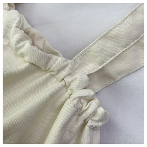 Primer plano del bolso de lona blanco crema que muestra la textura de la tela y las costuras