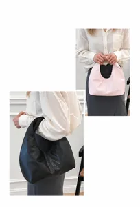 Detalle de los bolsos hobo de media luna rosa y negros con textura de cuero suave y asa curva