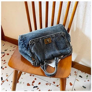 Makroaufnahme der blauen Denim-Schultertasche mit Vintage-Metallverschluss und Kettenriemen