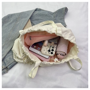 Detalle del interior del bolso de lona espacioso con bolsillo de cremallera y forro rosa