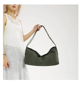 Detail of dark green matte textured hobo bag with wide shoulder strap and fine stitching