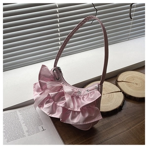 Detail of pink satin shoulder bag with layered ruffles and delicate ribbon bows
