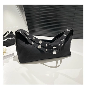 Close-up of vintage black canvas crossbody bag featuring stylish silver metal rivets