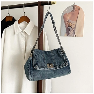 Detail der blauen Jeans-Umhängetasche mit Nietenelementen und metallischer Kette