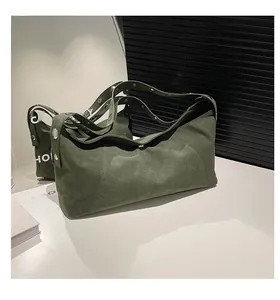 Detail of dark green suede crossbody bag featuring silver metallic rivet decorations