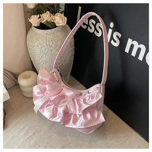 Detail of pink satin shoulder bag featuring layered ruffles and silk bow decoration