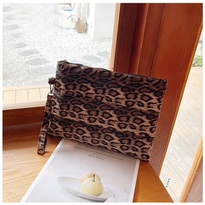 Detalle del neceser de peluche con estampado de leopardo, correa de mano y cremallera