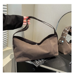 Detailed close-up of dark brown matte crossbody bag with silver metal studs on wide strap