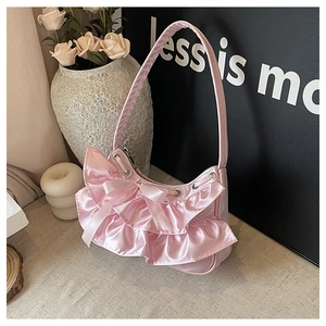 Detail of pink satin shoulder bag featuring a large bow and layered ruffle accents