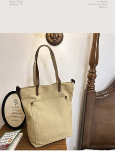 Detail of canvas tote bag showing dark brown handles and premium stitching details