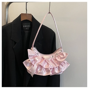 Detail of pink satin shoulder bag with oversized bow and elegant pleated ruffles