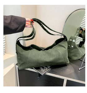 Detail of dark green suede hobo bag with metallic rivet studs on wide shoulder strap
