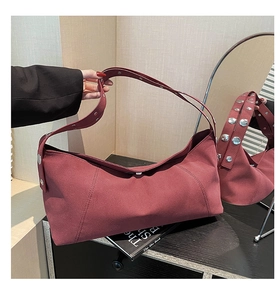 Detail view of burgundy frosted leather shoulder bag with metallic silver rivets decoration