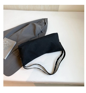 Detail of black crossbody bag with double row metal eyelets on the shoulder strap