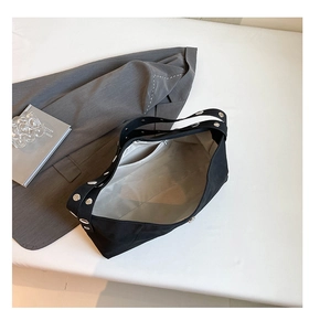 Detail view of large black canvas tote with silver eyelet strap and organized inner pockets