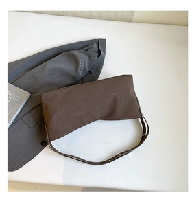 Detail of coffee canvas crossbody bag with vintage leather strap and metal eyelets