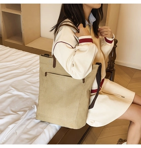 Detail view of khaki canvas tote bag with front pocket and durable brown shoulder straps