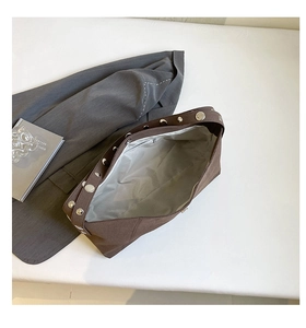 Detailed top view of brown tote bag showing inner zipper pocket and silver rivets