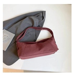 Close-up of retro burgundy tote bag with adjustable wide strap and metal eyelets