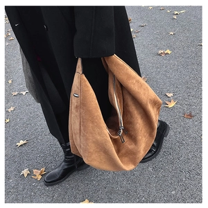 Detailed view of the brown suede hobo bag with dual metal zippers and side buckle