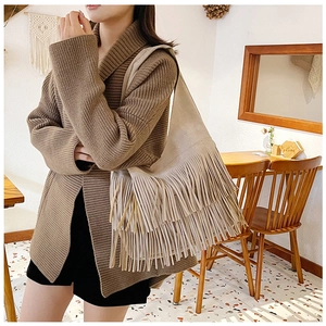 Detail van beige suède schoudertas met drielaagse lange franjes in bohemien stijl