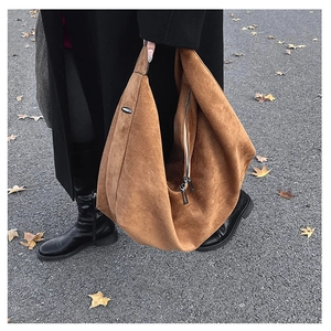 Detail of soft brown suede texture and metal zipper on this large tote bag for women