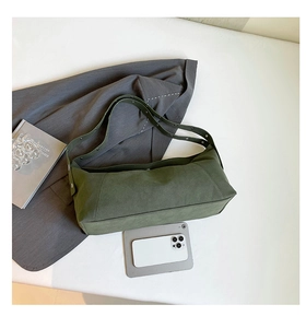 Detailed view of dark green frosted crossbody bag with adjustable studded strap on white surface