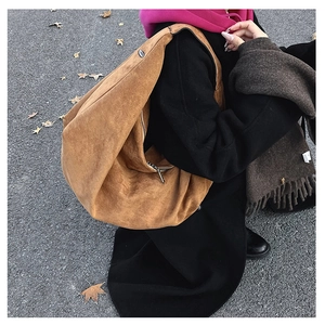 Detail of camel suede tote bag texture with elegant slouchy design and metal zipper