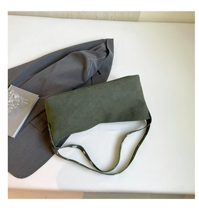 Detail of dark green suede hobo bag with white heart patterns on the shoulder strap