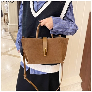 Close-up of brown frosted leather tote bag showing golden buckle and adjustable strap