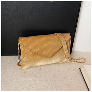 Detailed close-up of champagne gold envelope clutch with textured glitter and chain