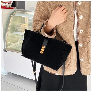 Detail of vintage matte black tote bag showing soft suede texture and gold metal buckle