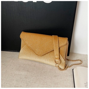 Detail view of a gold sequined envelope clutch with a metal snake chain strap