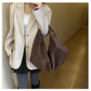 Brown suede tote bag shown on shoulder of a model for daily commute capacity check