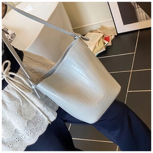 Detailed view of light blue crocodile pattern bucket bag with fashion leather embossing