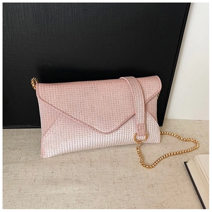Close-up of pink rhinestone envelope bag with fine sparkling texture and gold chain strap
