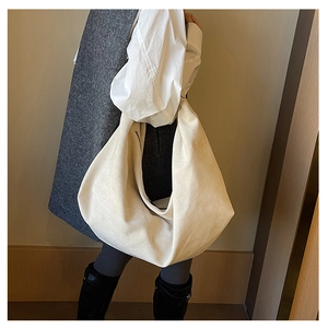 Detailed view of cream suede tote bag showing soft texture and slouchy half-moon shape