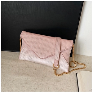 Detail view of sparkly pink gradient evening clutch with golden chain strap and rhinestones