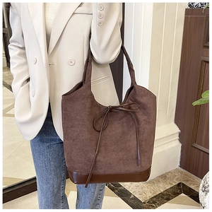 Détail du grand sac cabas en daim marron avec décoration nœud en cuir pour le bureau