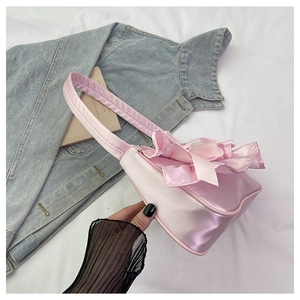 Detail of pink satin shoulder bag featuring elegant pleated ruffles and smooth texture