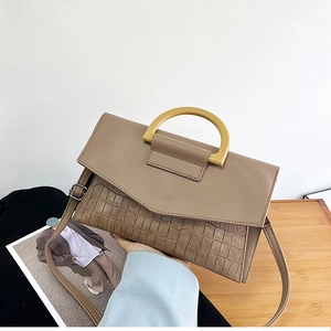 Detail view of khaki handbag with crocodile pattern texture and wooden handle