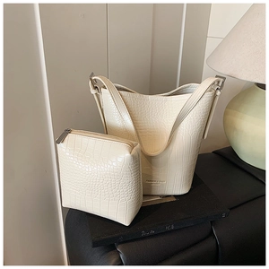 Detail of cream crocodile embossed leather bucket bag and matching coin purse set