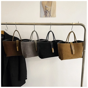 Detail view of suede tote bags in various earth tones with gold metal buckle hardware
