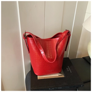 Macro shot of red crocodile texture bucket bag with silver metal strap buckle