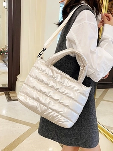 Chic beige quilted down tote bag with shoulder strap in stylish minimalist interior