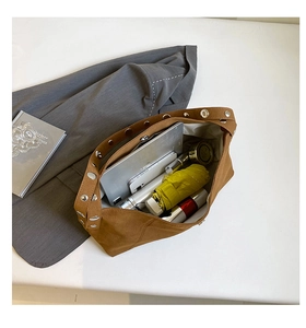 Spacious interior of brown suede hobo bag with silver rivets showing large storage capacity
