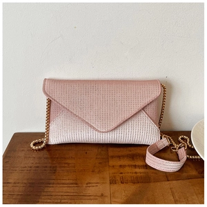 Detail of pink gradient sequin envelope bag with golden chain and sparkling texture